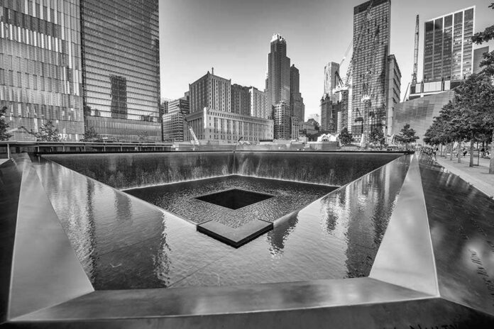 New,York,City,-,May,21:,9/11,Memorial,Geometric,Architecture A memorial water feature surrounded by tall buildings in a city