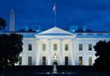 Congress Or Trump? Ballroom Fight Deepens White House illuminated at dusk with flagpole and columns