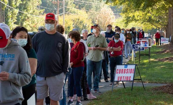 shutterstock_1834288405 Christian Jones and others waiting in a long line outside a polling place