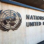 UN Blasted: Bloated, Biased, Useless? United Nations emblem and signage on a concrete wall