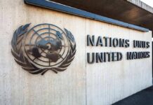 UN Blasted: Bloated, Biased, Useless? United Nations emblem and signage on a concrete wall