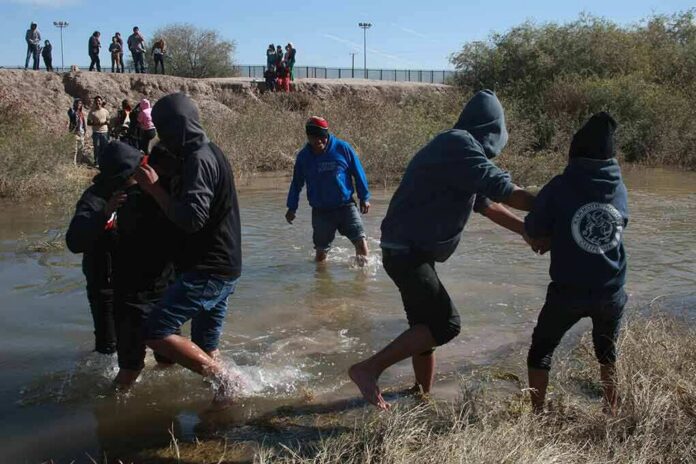 shutterstock_1928144615 Group of people wading through a shallow river