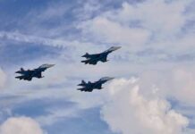 Three fighter jets flying in formation against a cloudy sky