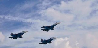 Three fighter jets flying in formation against a cloudy sky