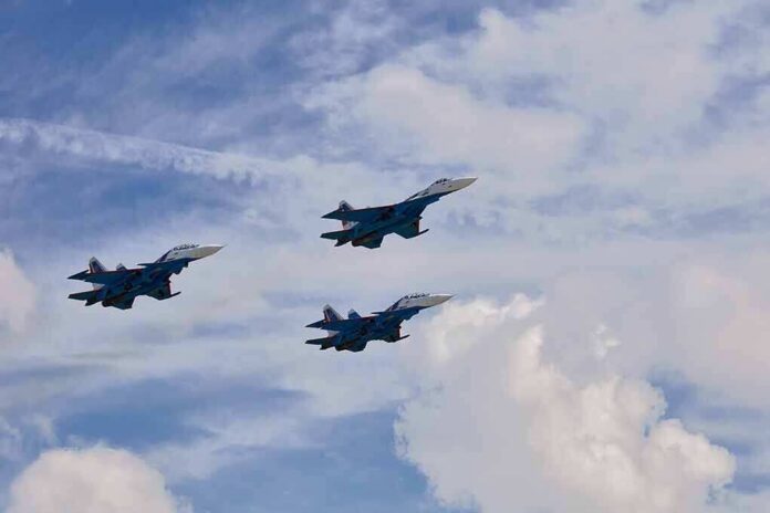 Three fighter jets flying in formation against a cloudy sky