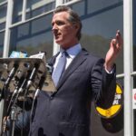 Newsom’s Kill Switch Sparks Tech Panic Gavin Newsom speaks at a press conference with microphones outside a building
