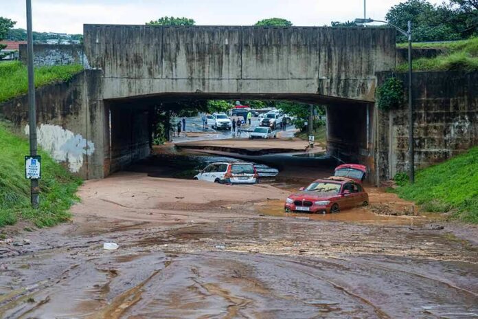 Flooded underpass with stranded cars in muddy water