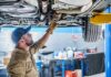 California’s Crazy New Tire Law! Mechanic inspecting underside of a car on a lift