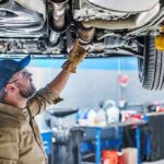 California’s Crazy New Tire Law! Mechanic inspecting underside of a car on a lift