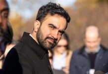 Immigration Whiplash Rattles NYC Services Man in a dark coat outdoors looking toward the camera