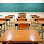 School Cash Twist Splits Democrats Empty classroom with rows of wooden desks facing a large chalkboard