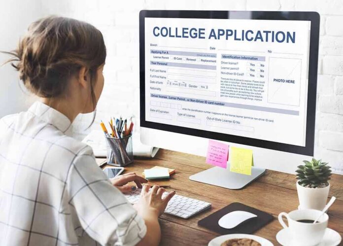 shutterstock_497727625 Student completing a college application on a desktop computer