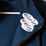 Illegal Voting Busts Jolt DOJ Map Jacket with I Voted stickers on the collar