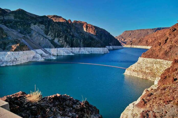 Reservoir between rugged desert cliffs with stark white shoreline