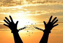 Silhouette hands breaking chains at sunset
