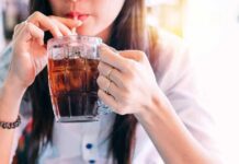 Paper Straws Trigger Cancer Panic? person sipping iced drink from a glass mug with a straw