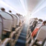 Stabbing Turns Routine Flight Into Nightmare Airplane cabin aisle with blurred passengers and seats