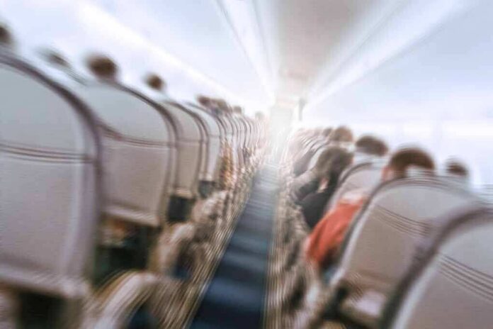 Airplane cabin aisle with blurred passengers and seats
