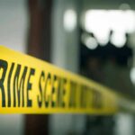 Nightmare on Perry Street – 9 Lives Ended crime scene tape in a blurred indoor setting