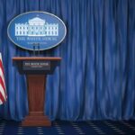 Network Alliance Exposed? DOJ Digs In White House press briefing podium with U.S. flag and blue curtain