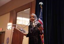 Ilhan Omar speaking at a podium with a microphone
