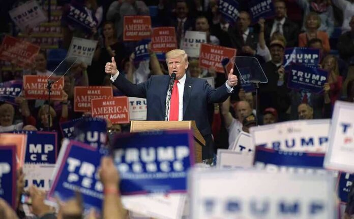 shutterstock_1427778638 Donald Trump speaks at a rally, giving two thumbs up