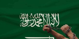 Hands breaking chains over a green flag with Arabic script and a sword
