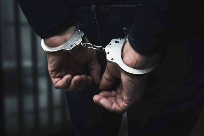 shutterstock_1589688214 hands in handcuffs behind back
