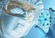 Plague Lab Death Sparks Global Watch Scientist in protective gear examining a petri dish