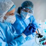 CDC Drops Bomb On Infertility Rumors Scientists in protective gear working with a syringe in a laboratory
