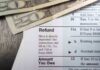 Close-up of tax refund form with cash on a wooden surface