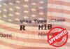 Layoff Red Flags Trigger H‑1B Heat H1B visa document with U.S. flag overlay and red Approved stamp