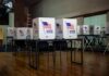 Voting booths with American flags in an empty polling place