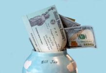 Bill jar with U.S. Treasury check and cash sticking out