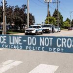Daylight Horror On A Chicago Sidewalk Police line barrier blocking a street with patrol vehicles behind