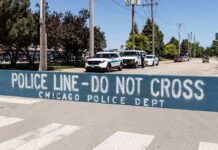 Daylight Horror On A Chicago Sidewalk Police line barrier blocking a street with patrol vehicles behind