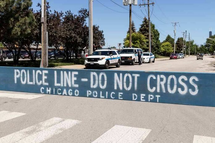 Police line barrier blocking a street with patrol vehicles behind