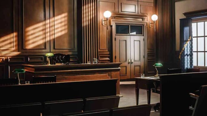 shutterstock_2056420760 Empty courtroom with wooden benches and judge's bench