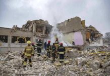 Firefighters search rubble of a partially collapsed building