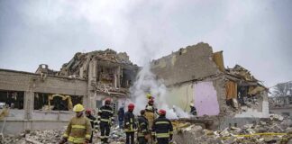 Firefighters search rubble of a partially collapsed building