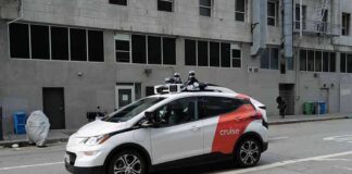 Autonomous test car with roof sensors on a city street