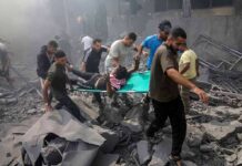 Rescuers carry an injured person on a stretcher through rubble