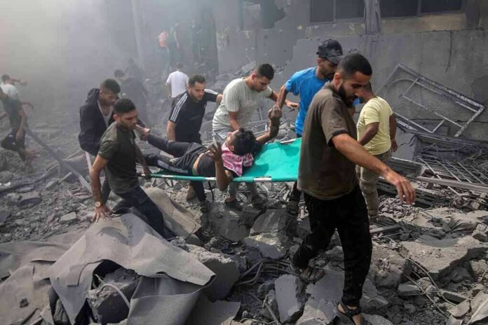 Rescuers carry an injured person on a stretcher through rubble