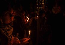 People holding candles at a nighttime vigil