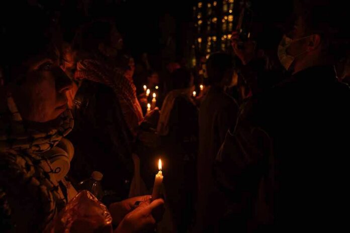 People holding candles at a nighttime vigil