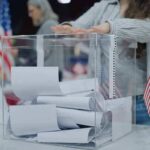 Inmate Candidate Exploits Loophole Person casting a ballot into a clear box at a polling station
