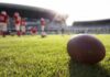 American football on a grass field at a stadium
