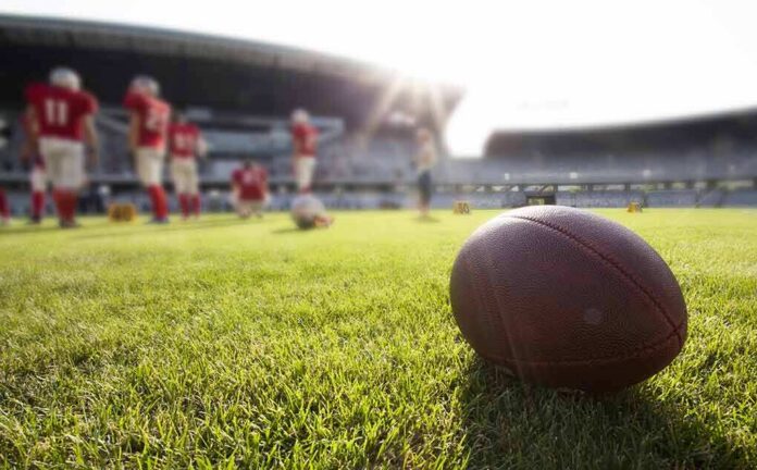 American football on a grass field at a stadium