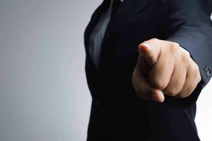 shutterstock_557194924 Person in a suit pointing directly at the camera
