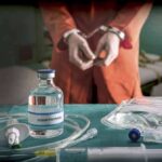 Florida Grants Inmate’s Chilling Request Medical vials and IV lines on a table with a handcuffed person in the background